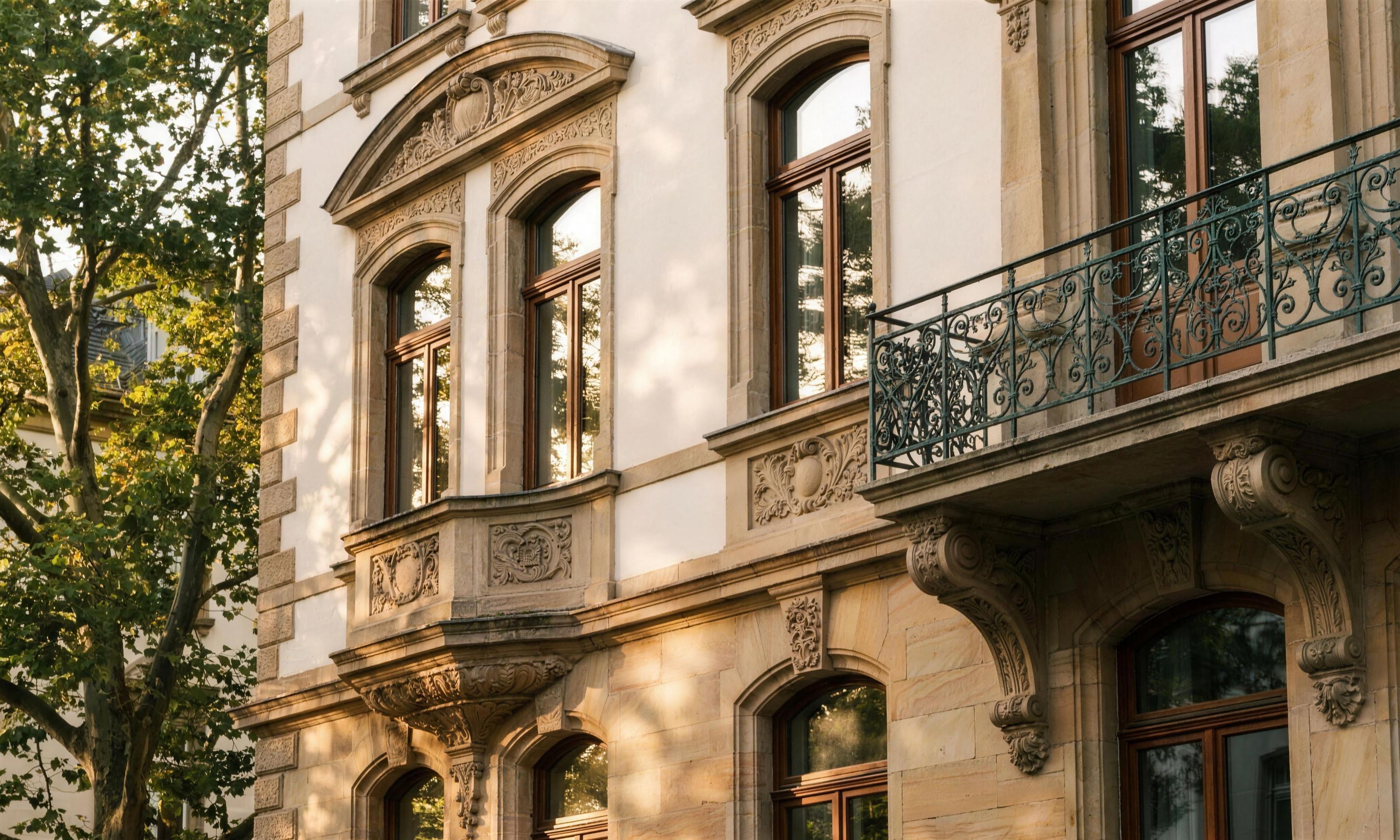 Sanierte Gründerzeit-Fassade in Stuttgart-West mit Sandstein, Stuck und schmiedeeisernem Balkon im Abendlicht